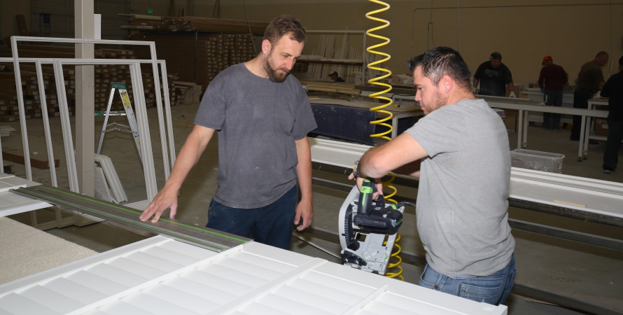 two guys assembling a multi-panel shutter