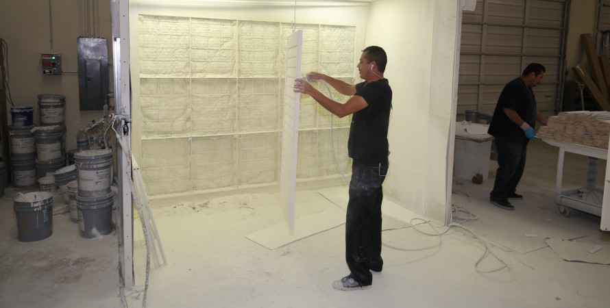 man painting a shuttter in the custom paint booth